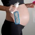donna in gravidanza con detergenti per pulire la casa