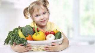 bambina con un cesto di frutta a verdura