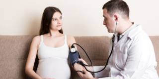 medico misura la pressione a donna con pre-eclampsia