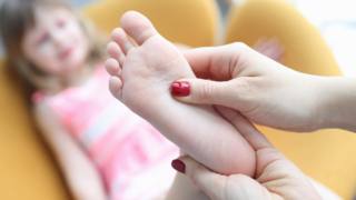 bambina con piedi piatti massaggiati dalla mamma