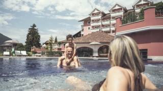 Al Cavallino Bianco Family Spa Grand Hotel ci si può rilassare e rinfrescare in una delle tante piscine esterne e interne godendo del panorama mozzafiato delle Dolomiti