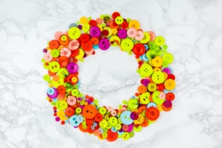Scattered colorful buttons on white table. Circle frame from multicolored buttons in a center of the picture. Copy space. Sewing or tailoring work. Home needlework. Flat lay banner with button Scattered colorful buttons on white table. Circle frame from multicolored buttons in a center of the picture. Copy space. Sewing or tailoring work. Home needlework. Flat lay banner with button