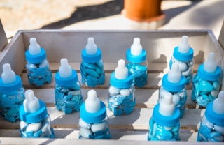 Favor in the form of child bottles filled with candies for the guest attending the boy baptism