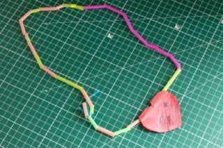 Child activity, necklace made with straws and a little red heart of paper