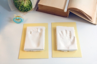 Baby footprint and handprint on clay mold plaque To remember in the future how small the baby was. cheerful childhood celebration event- Baby DIY keepsake to keep forever