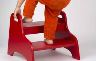 La torre montessoriana, a differenza di un noemale sgabello, è più sicura per i bambini piccoli perché dotata di maniglie che aiutano il bambino a salire i gradini