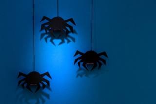 Black paper spider with web on dark blue background. Halloween concept. Paper cut style. Top view Black paper spider with web on dark blue background. Halloween concept. Paper cut style. Top view
