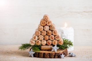handmade-creative-christmas-tree-decoration-made-with-wine-bottle-corks-white-candle-burning-on-wooden-background-lot-of-copy-space-upcycling-concept handmade-creative-christmas-tree-decoration-made-with-wine-bottle-corks-white-candle-burning-on-wooden-background-lot-of-copy-space-upcycling-concept