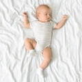 neonato che dorme con braccia alzate