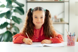 bambina che scrive un riassunto bambina che scrive un riassunto