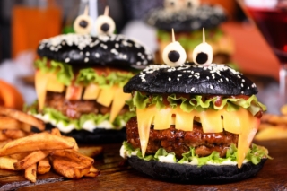 Monster Burger. Black bun, juicy beef cutlet, lettuce, onion, tomato and cheese in the shape of teeth, mozzarella eyes with olives. Definitely a pick-me-up and a perfect Halloween party appetizer. Monster Burger. Black bun, juicy beef cutlet, lettuce, onion, tomato and cheese in the shape of teeth, mozzarella eyes with olives. Definitely a pick-me-up and a perfect Halloween party appetizer.